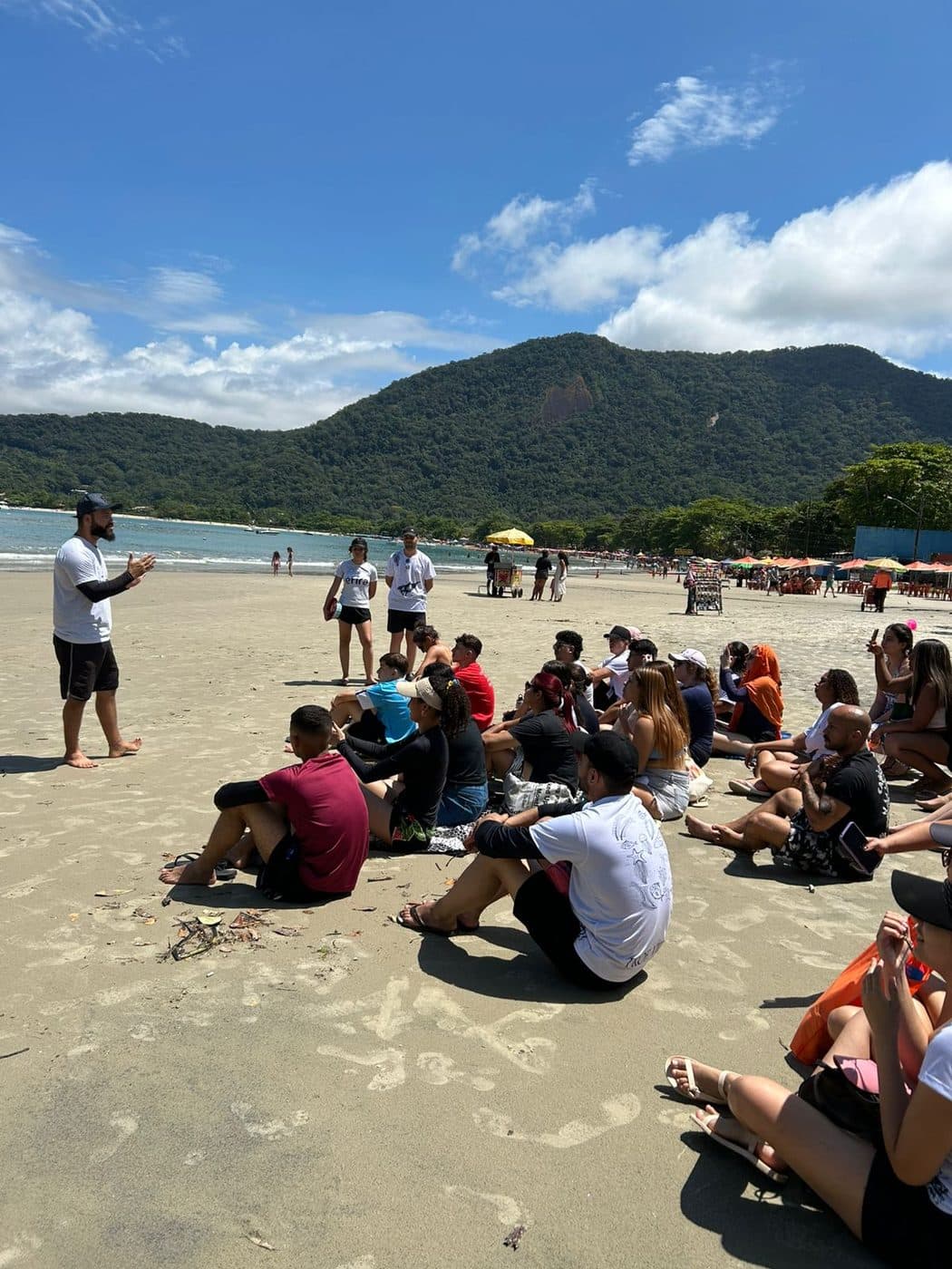 Aula prática na praia, com o grupo reunido para falar sobre os ecossistemas costeiros